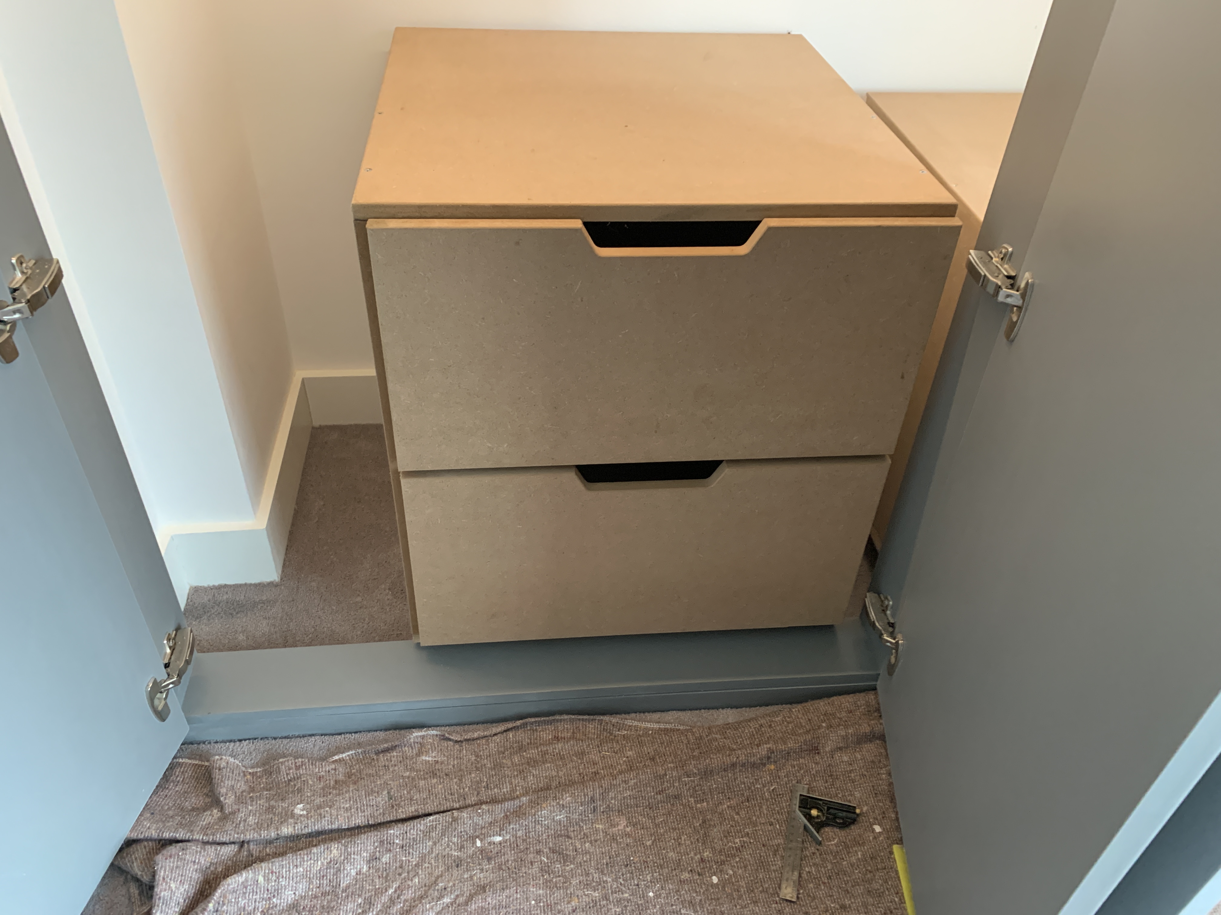 A small drawer unit built into the bottom of a built in wardrobe.